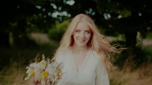 Beautiful Blonde Woman Walking and Looking Into Camera alt