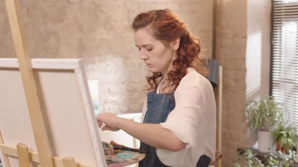 Curly Woman Painting in Studio alt