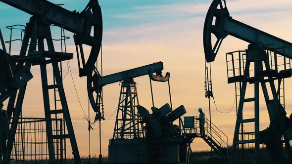 Crude Oil, Gas, Petroleum Prices Concept. Engineer Is Observing an Oil Development Site alt