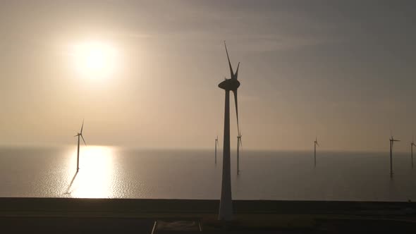 Aerial view Along scenic Wind park on Sea, Sunlight reflection on Water surface, Dolly shot alt