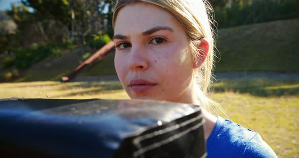 Portrait of teenage girl holding boxing equipment during obstacle course alt