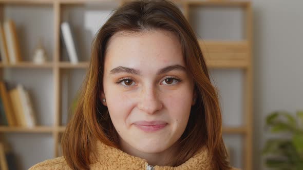 Happy Cute Positive Caucasian Brunette Young Woman Sitting on Sofa on Living Room Background Looking alt