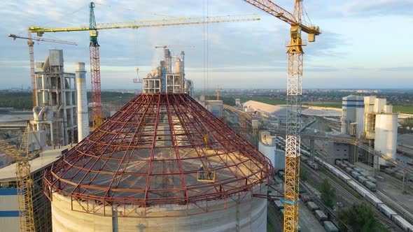 Aerial View of Cement Factory Under Construction with High Concrete Plant Structure and Tower Cranes alt