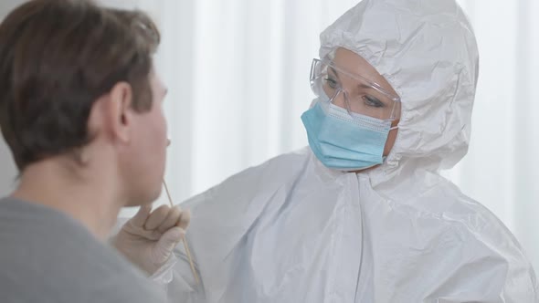Closeup of Professional Caucasian Female Nurse Taking Covid19 Test Using Cotton Swab alt