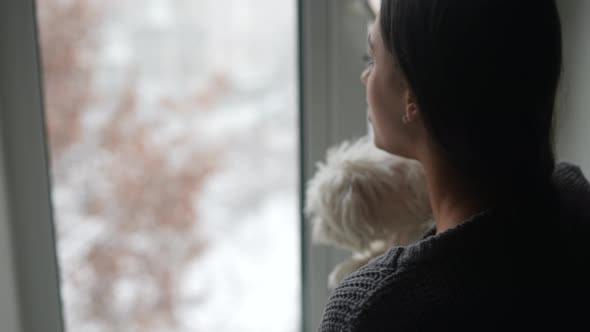 Woman Hugging Cute Dog Looking Out the Window alt