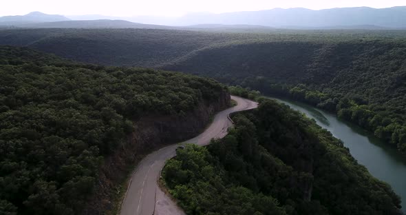 Epic Aerial Shot Car Driving with Mountain Forest Background in the Summer