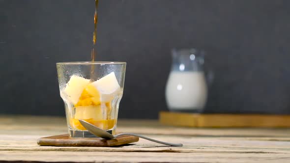 Pouring Hot Coffee In Glass With Milk Ice Cubes