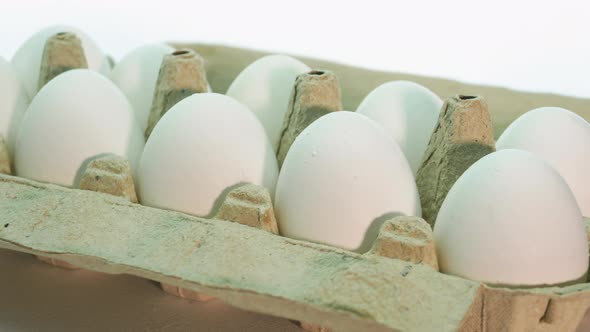 Close Up Chicken Eggs In A Paper Tray Are Spinning On A White Background, White Chicken Eggs alt