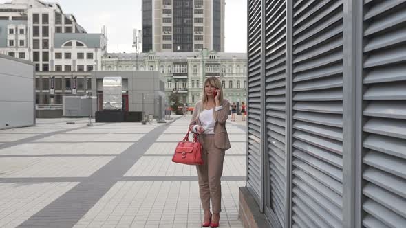 Business woman talking on the phone in a big city. alt