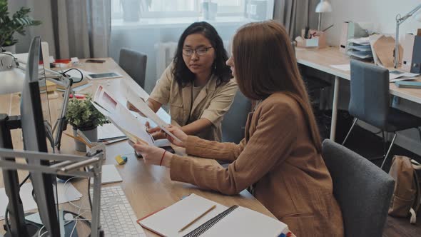 Female Colleagues Discussing Business Documents alt