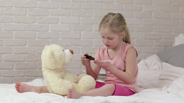 Cute Child Girl Playing Doctor with Teddy Bear