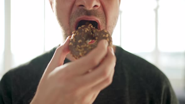 Man Eating Sweet Chocolate Donut alt