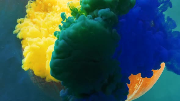 Yellow and Blue Paints Cover Pumpkin with Cut Face in Water alt
