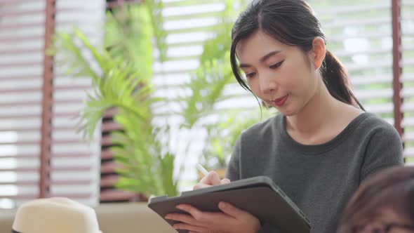 asian female adult long black hair working hand use tablet device working alt