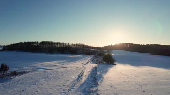 Aerial Drone View of a Fields Covered with Winter Snow during Sunset