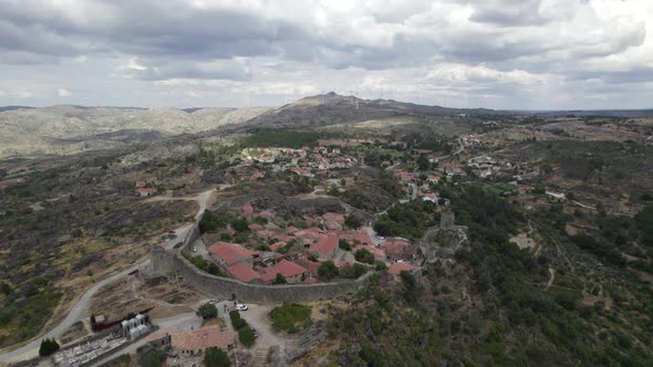 Drone aerial panoramic view of Sortelha historic village and wind turbines in natural landscape, Por