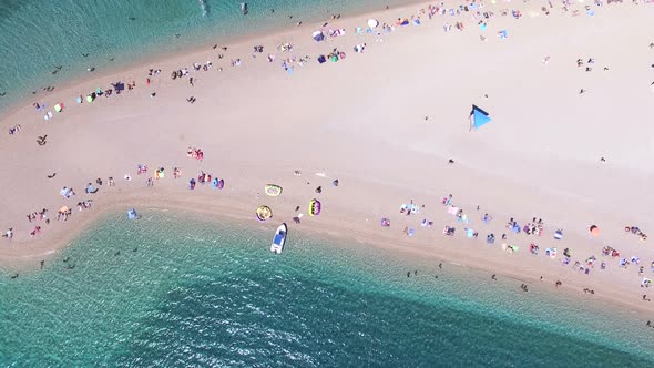 Aerial view of people sunbathing on a sandy beach on the island of Brac, Croatia alt