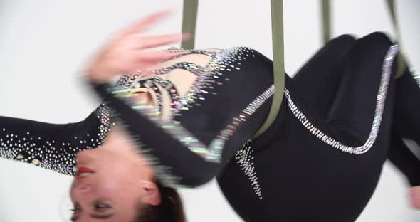 Athletic Young Woman in Black Costume is Doing Aerial Silks Spinning alt