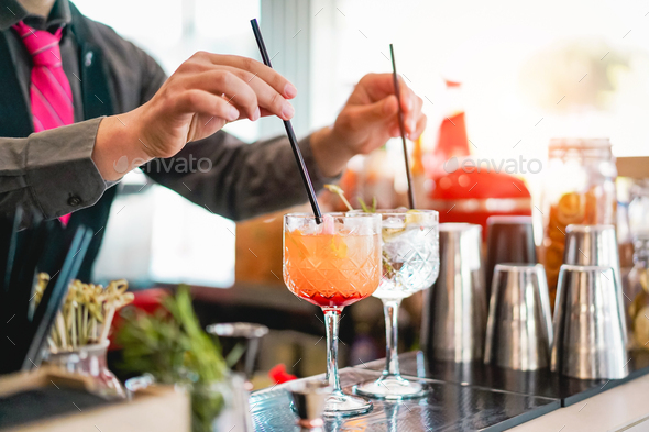 Young bartender making cocktails at bar counter