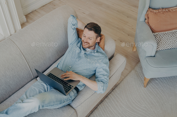 Young business company worker in casual clothes relaxing after successful online presentation