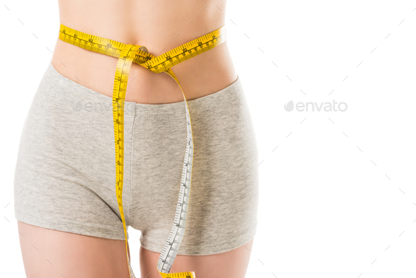 Woman Measuring Her Waist With A Yellow Measuring Tape, Isolated