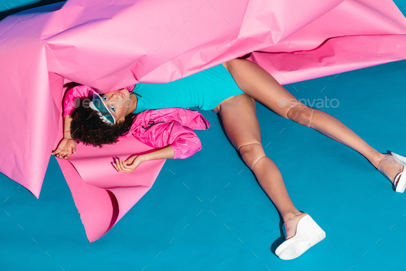 beautiful african american model posing with pink paper for fashion shoot  in 80s style Stock Photo by LightFieldStudios