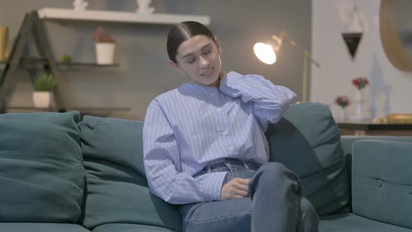 Sick Hispanic Woman having Toothache while Sitting on Sofa alt