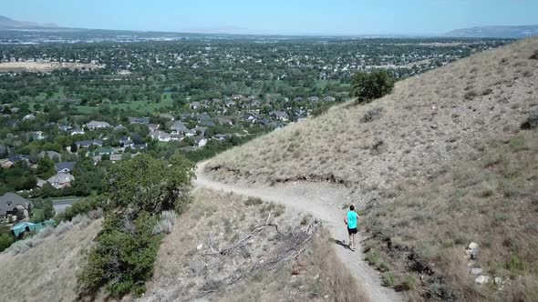 Drone Shot following an active man running on the outdoor mountain trails above Draper City, Utah. T alt
