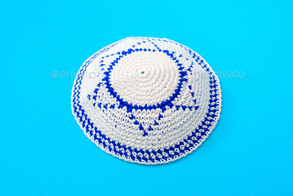 Kippah is a circular hat, with the flag of Israel, isolated on a blue background.