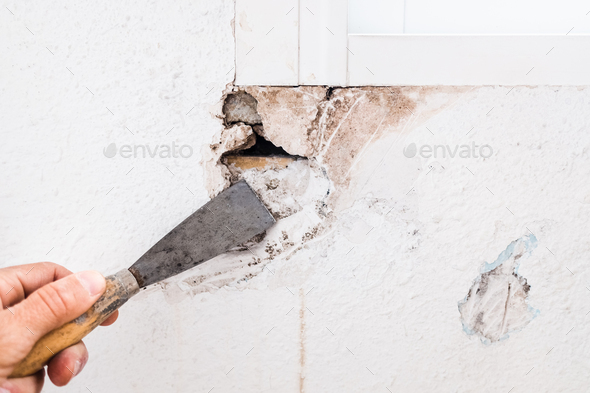 Detail of the repair of a hole in the wall of the living room using filling mass.