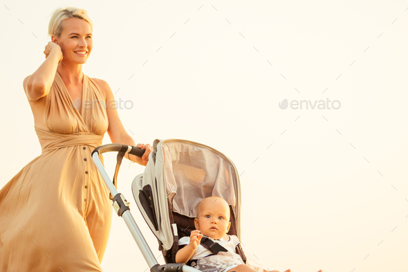 beautiful mother and her cute child walking before going to sleep on the beach