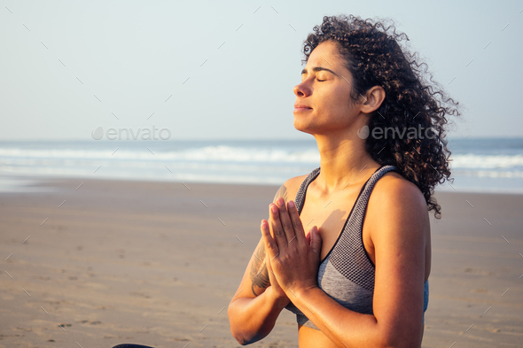 afro america woman with curly hair and closed eyes deep breathing and calming