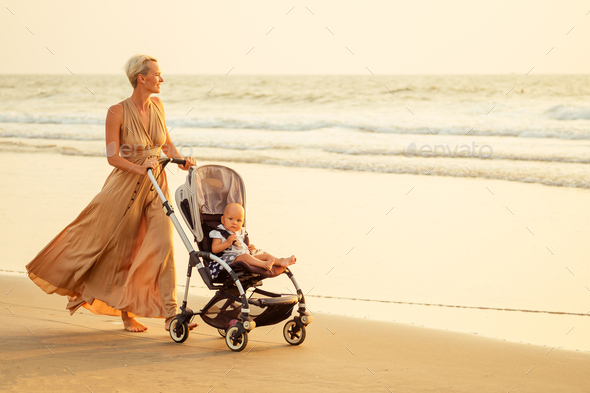 beautiful mother and her cute child walking before going to sleep on the beach