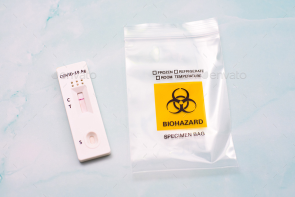 A covid-19 antigen test is discarded in a biohazard bio-waste bag