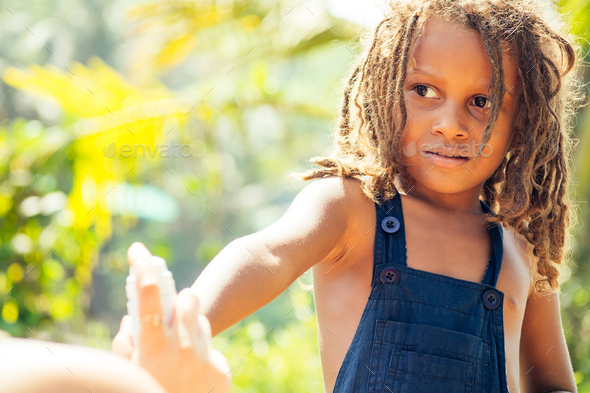 Mowgli indian boy with dreadlocks hair hiding holding mosquito spray in ...