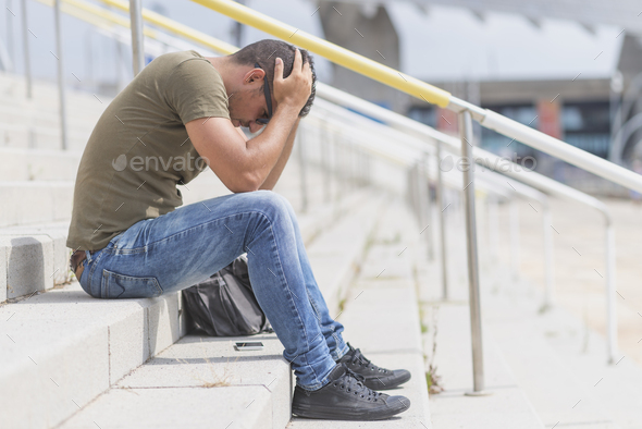 Man who lost job abandoned lost in depression sitting on stairs suffering emotional pain