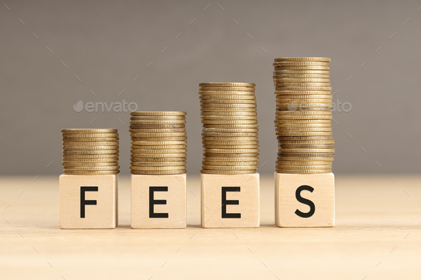 Fees word in wooden blocks with coins stacked - Stock Photo - Images