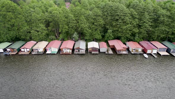 Aerial view of huts by the lakeside forest of Lake Mirow in Germany. alt