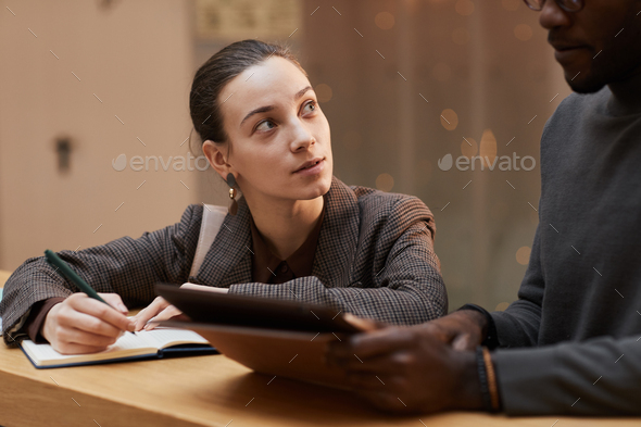 Young Woman Taking Notes with Manager