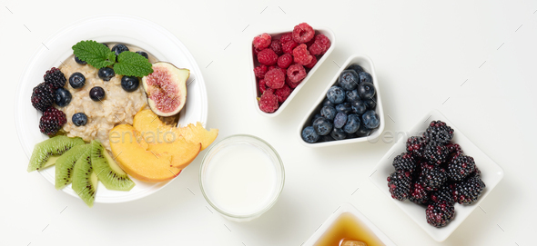 Milk, plate with oatmeal porridge and fruit, freshly squeezed juice