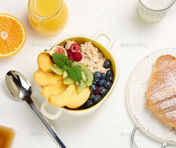 Plate with oatmeal and fruit, half a ripe orange and freshly squeezed juice