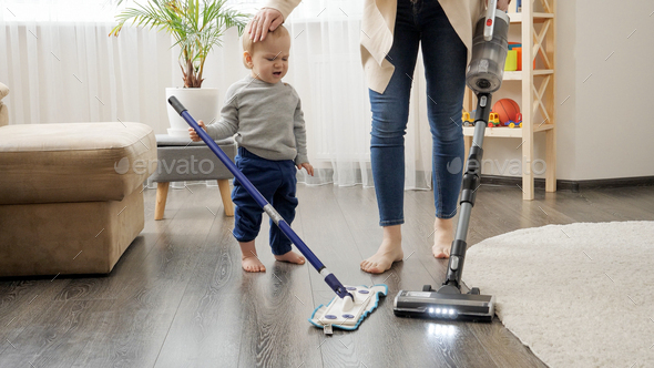 Little baby boy helping his mother doing cleanup at house - Stock Photo - Images