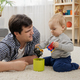 Young father lying on carpet with his baby son and playing with toys - PhotoDune Item for Sale