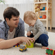 Little baby boy giving toys to his father for playing on carpet. - PhotoDune Item for Sale