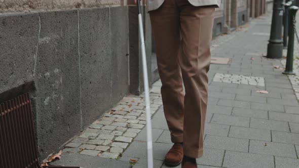 Visually Challenged Man Walking on Street with Grocery Bag alt