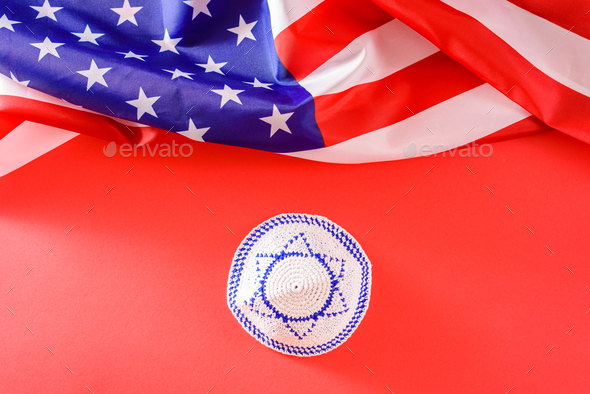 Kippah with the Israeli flag, next to an American flag, the United States is a protective country