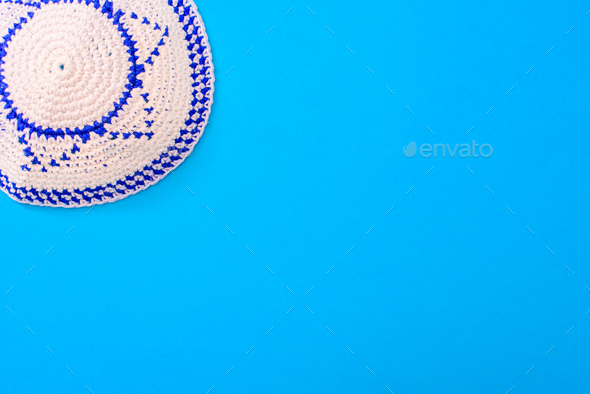 Kippah is a circular hat, with the flag of Israel, isolated on a blue background.