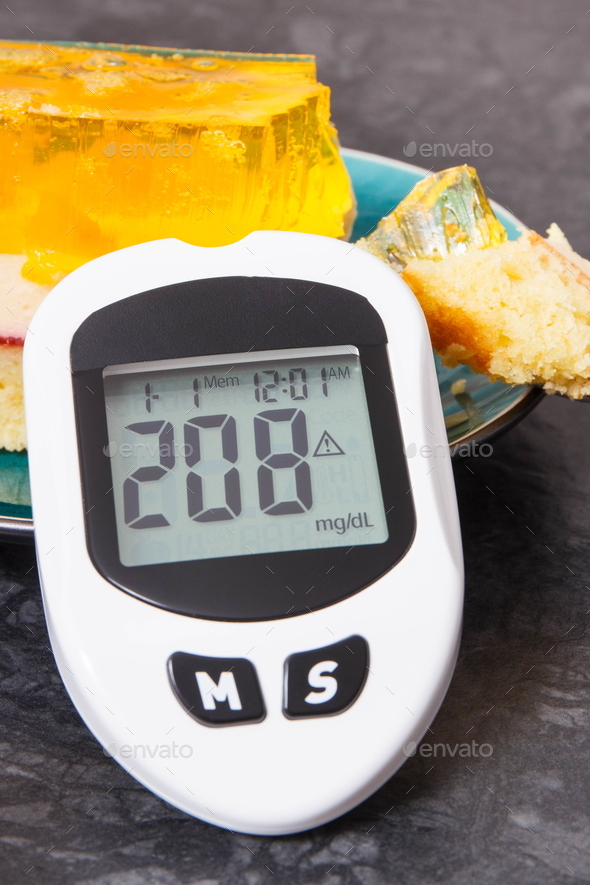 Glucometer with high sugar level and creamy fruit cake with jelly. Nutrition during diabetes