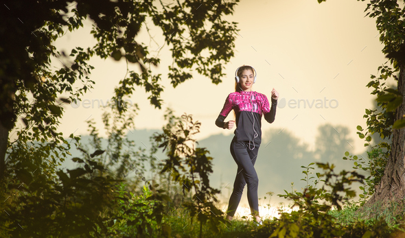 Female runner running in nature during sunrise