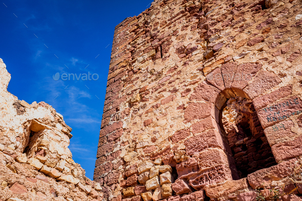 Walls of an old abandoned European castle with blue sky background.